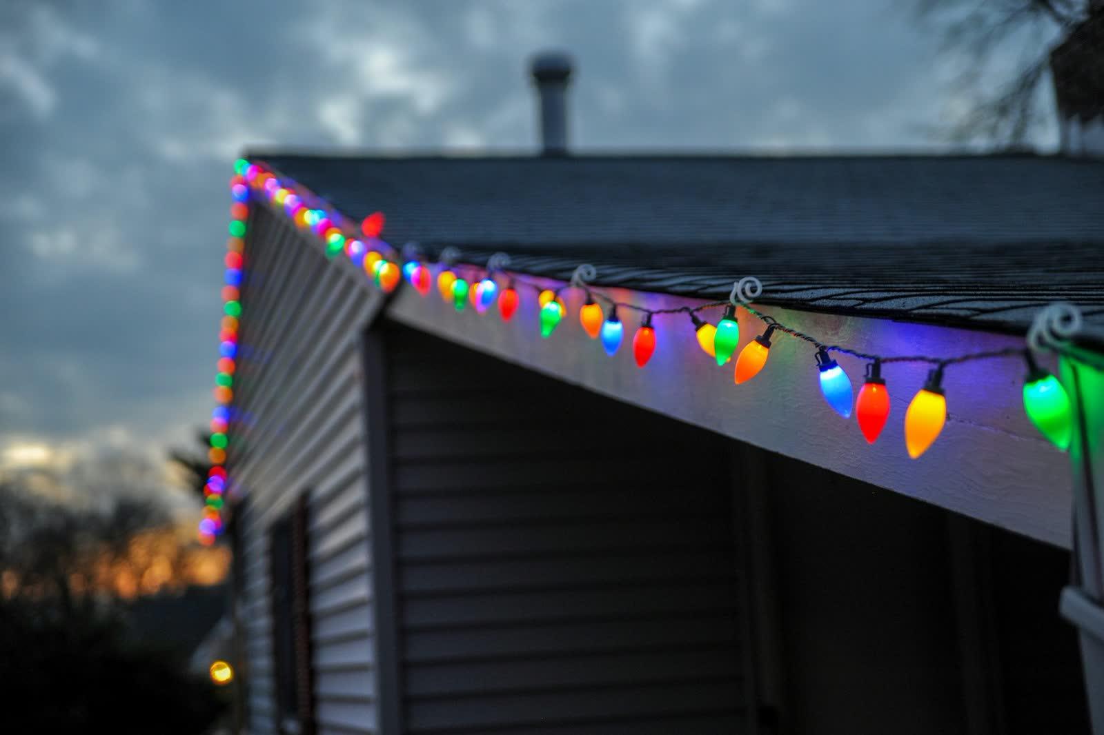 String lights installed along the roofline of a house at dusk