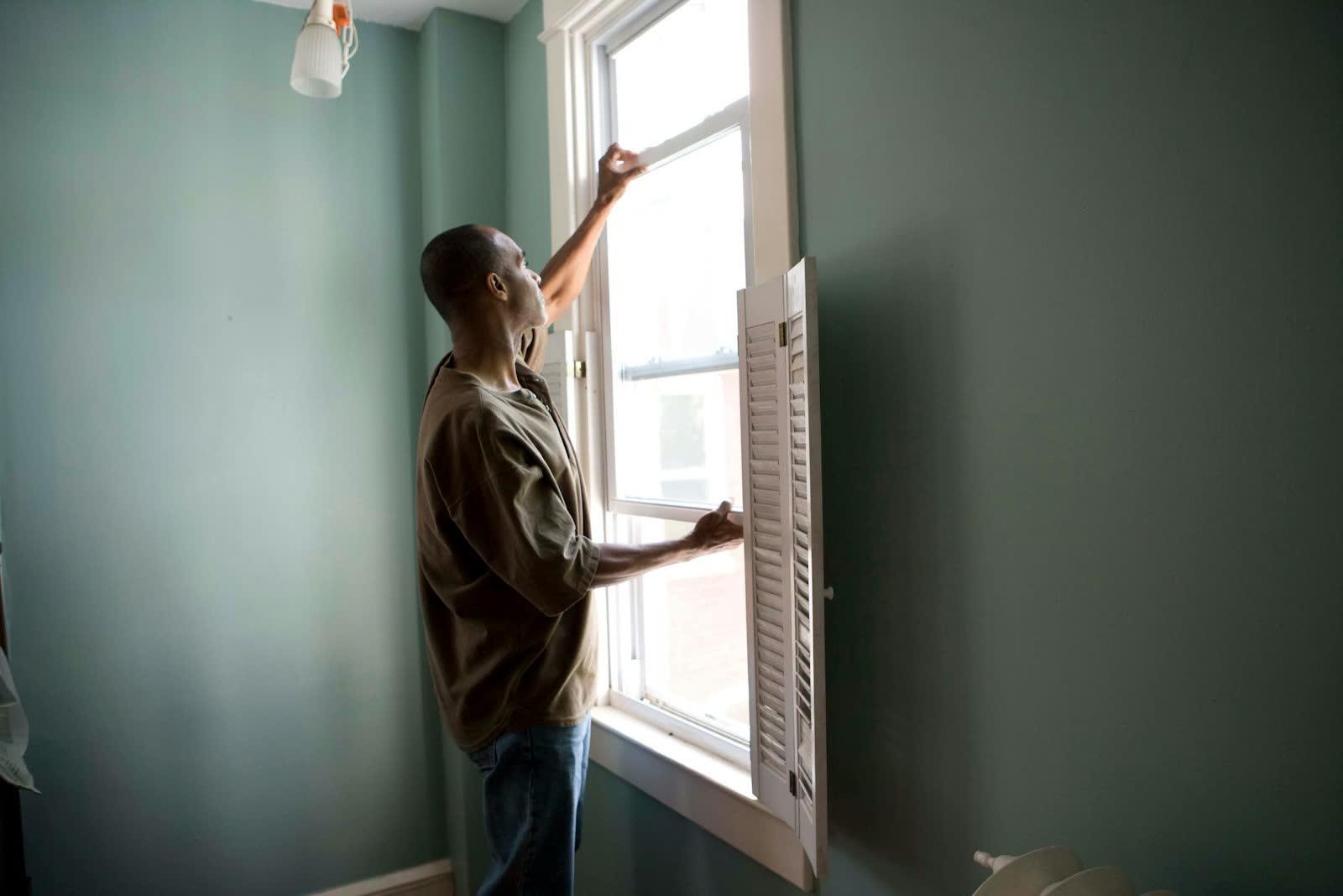 Installer fitting a new window in a home